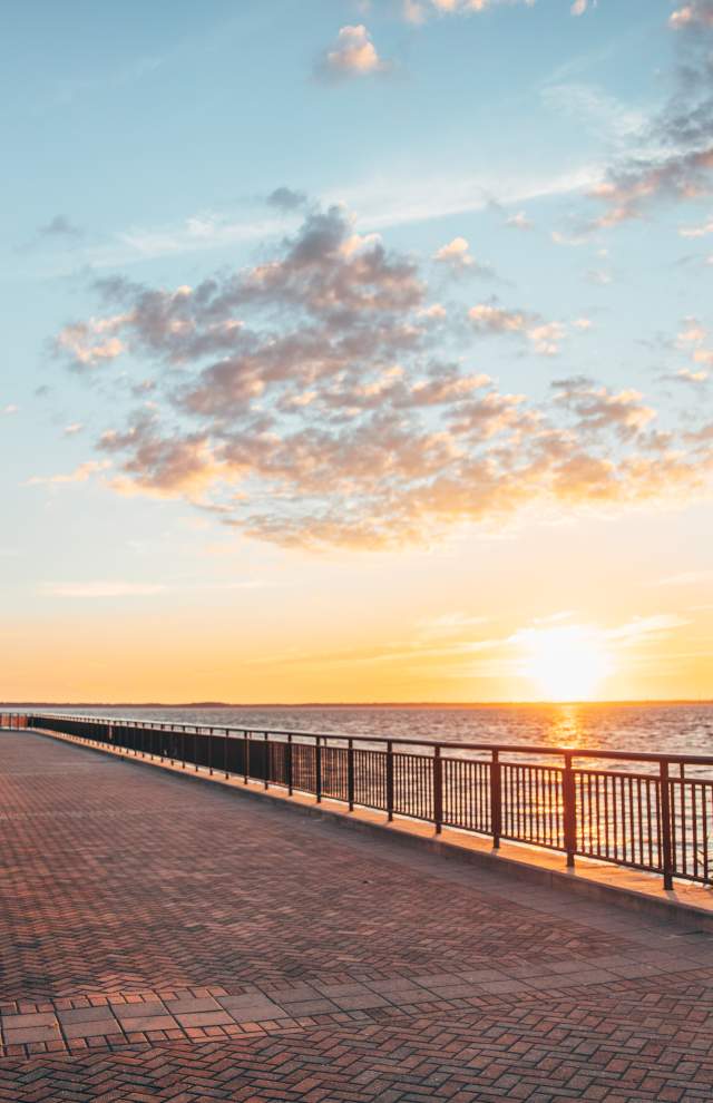 Scenic view of the James River with a bench in the foreground at sunset