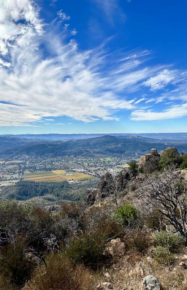 view of blue sky with clouds from atop hood mountain in sonoma valley showing parts of the valley below