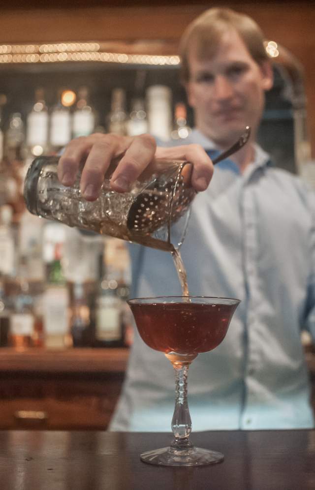 A downtown Columbia SC bartender pouring a whisky drink at the bar