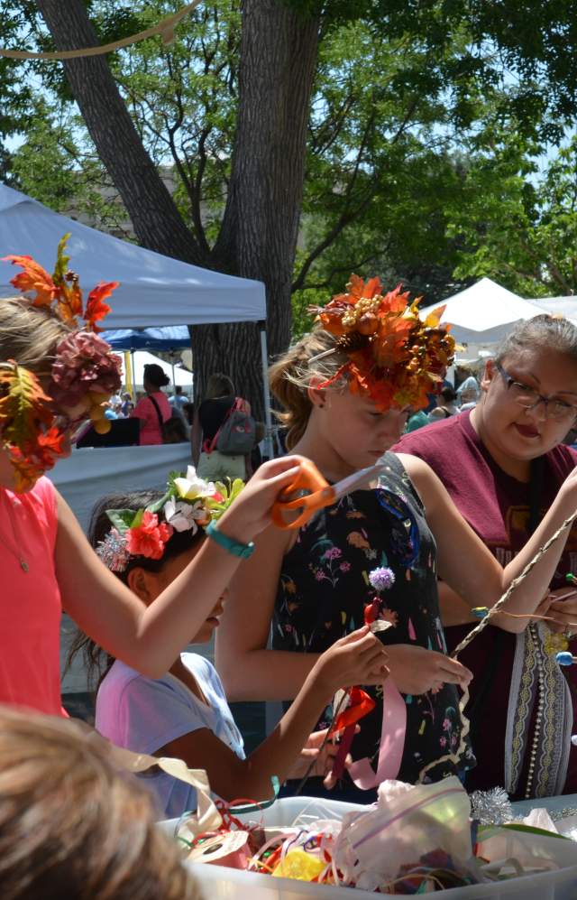 Attendees at the Arts Picnic making crafts at the creation station.