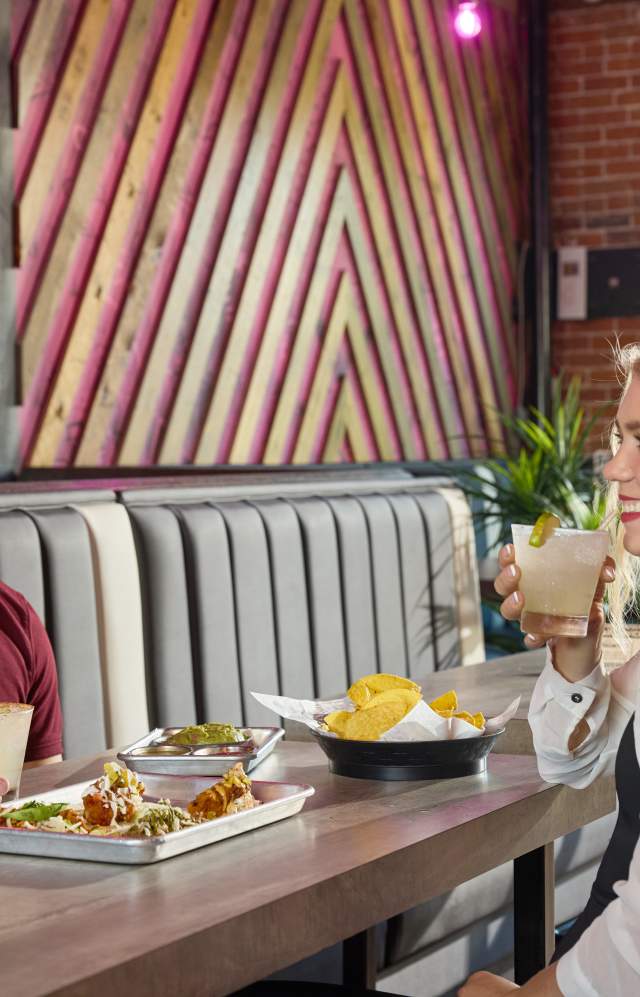 Couple enjoying tacos, drinks and chops together
