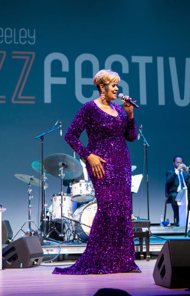 Women in purple dress singing with jazz band in the background at UNC Jazz Fest 2025