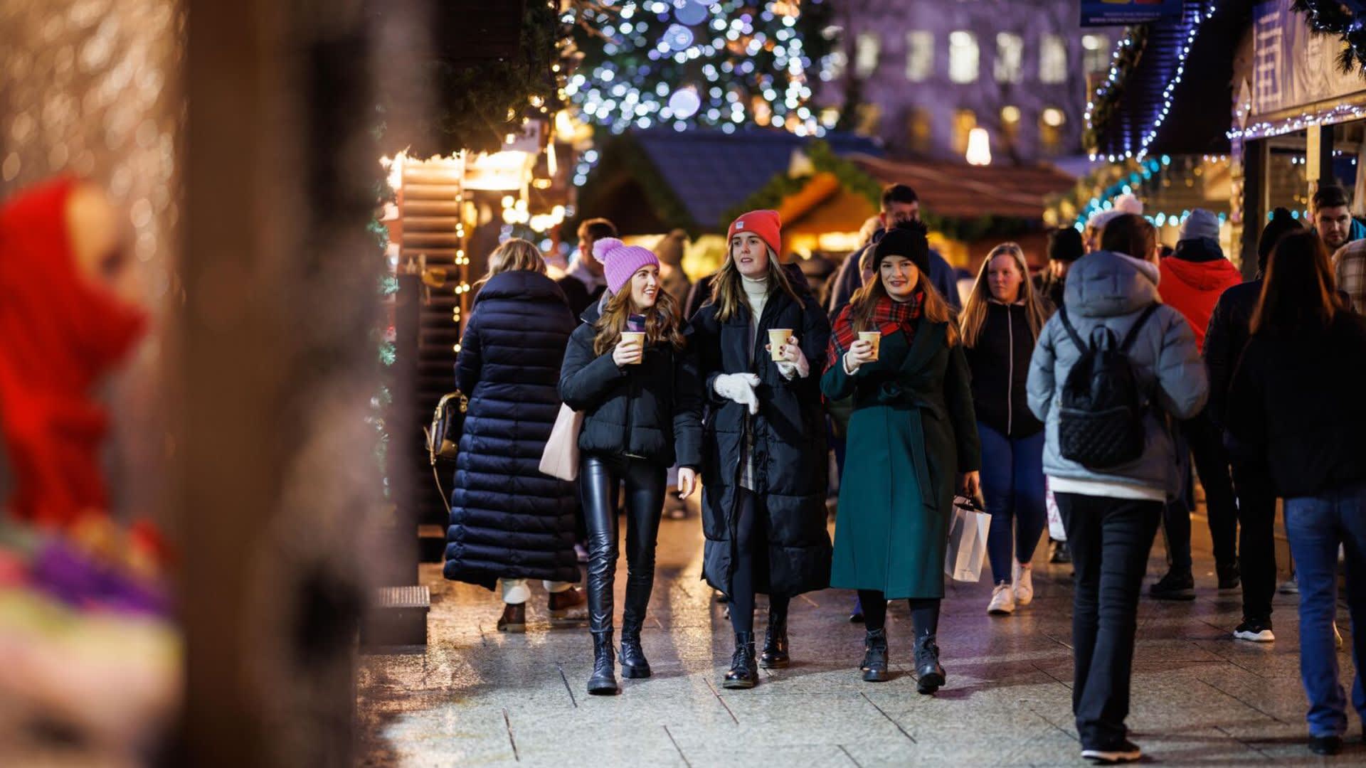 Three girls walking through the Belfast Christmas Market
