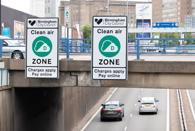 Signs next to road warning clean air zone charges apply