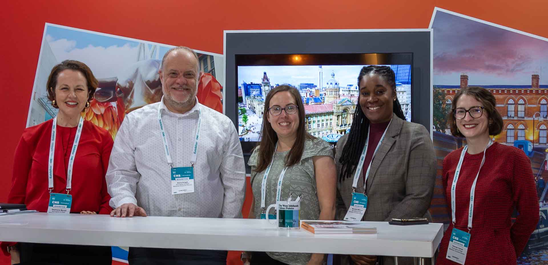 Five people in front of a trade show stand