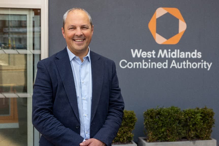 Ed Cox standing beside a sign for the West Midlands Combined Authority