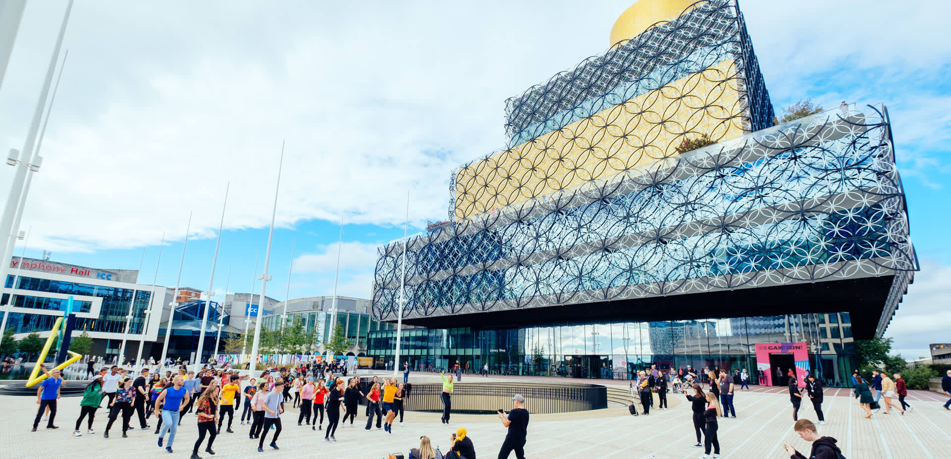A group of people standing in Centenary Square in front of the Library of Birmingham