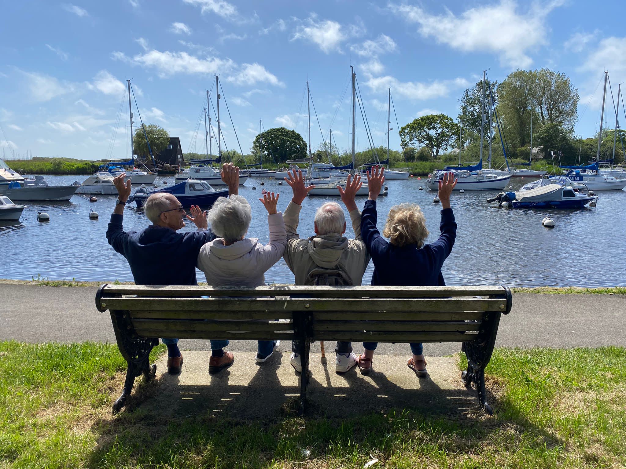 People sat on bench looking out across Christchurch Quay