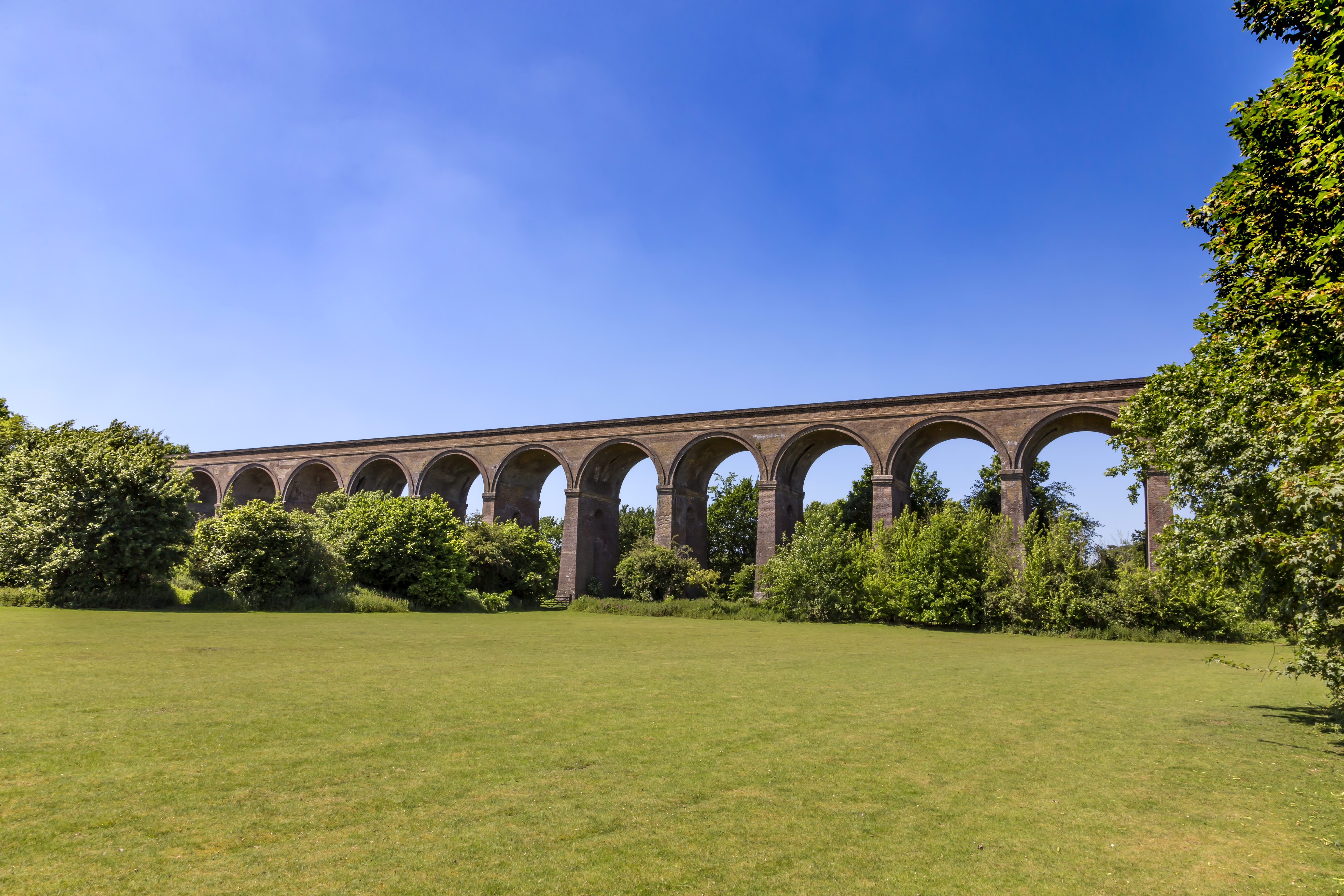 Chappel Viaduct surrounded by trees and blue skies