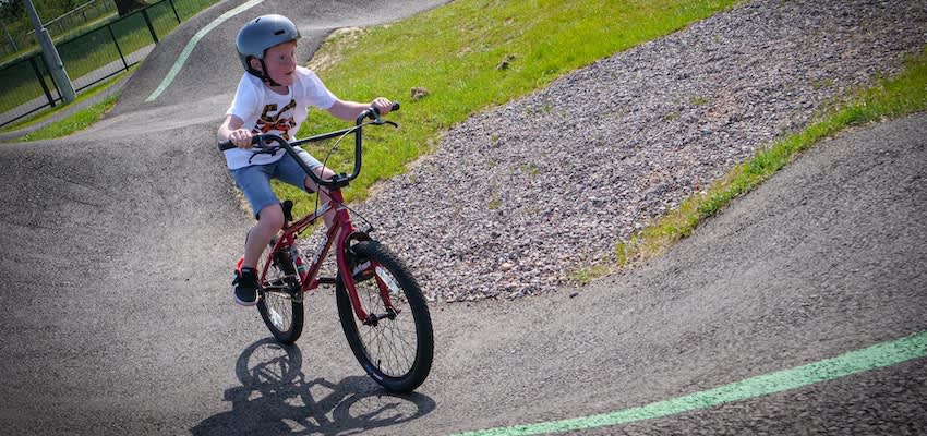 A child rides a pump bicycle on a track