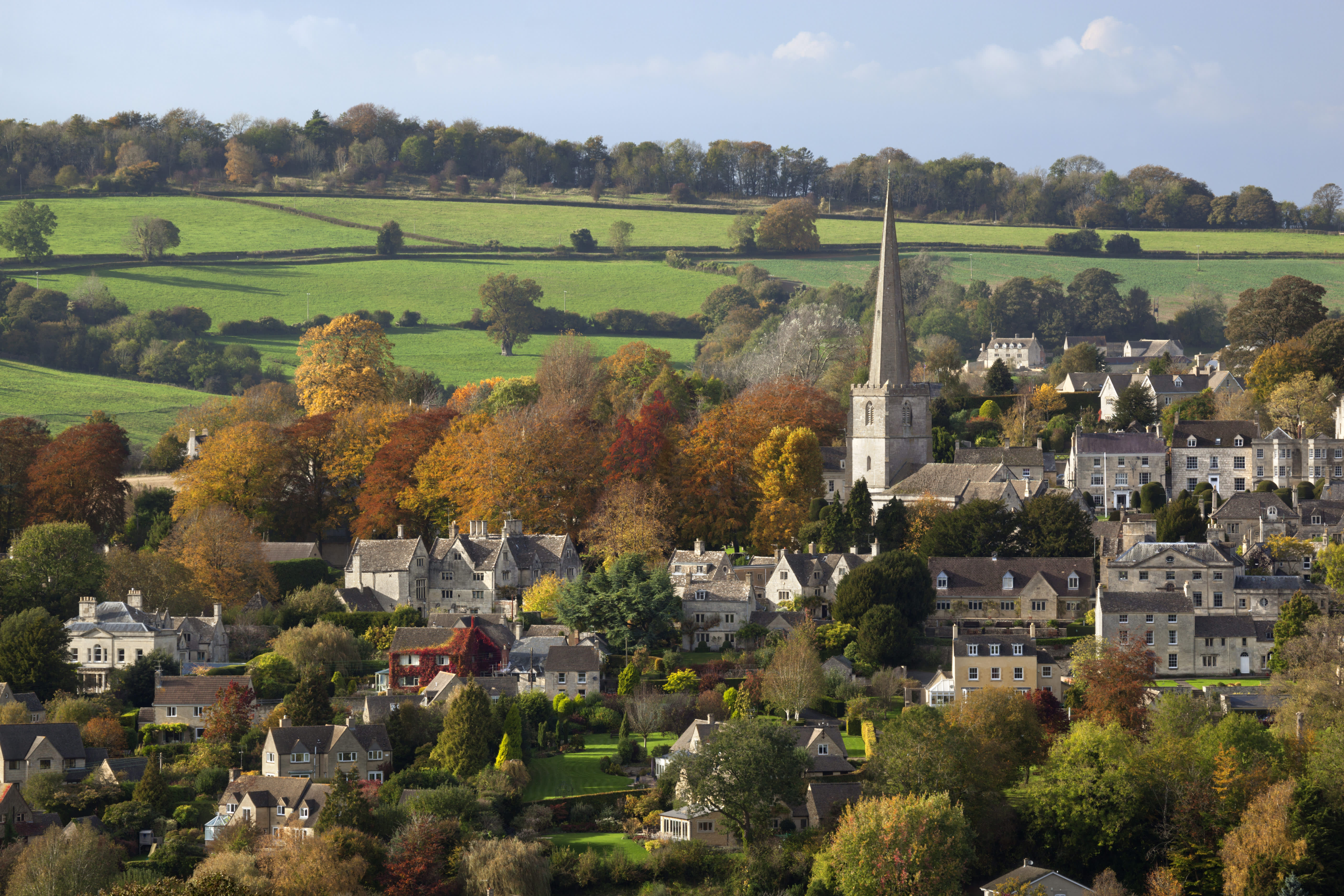 The town of Painswick with towering steeple, surrounded by autumnal countryside