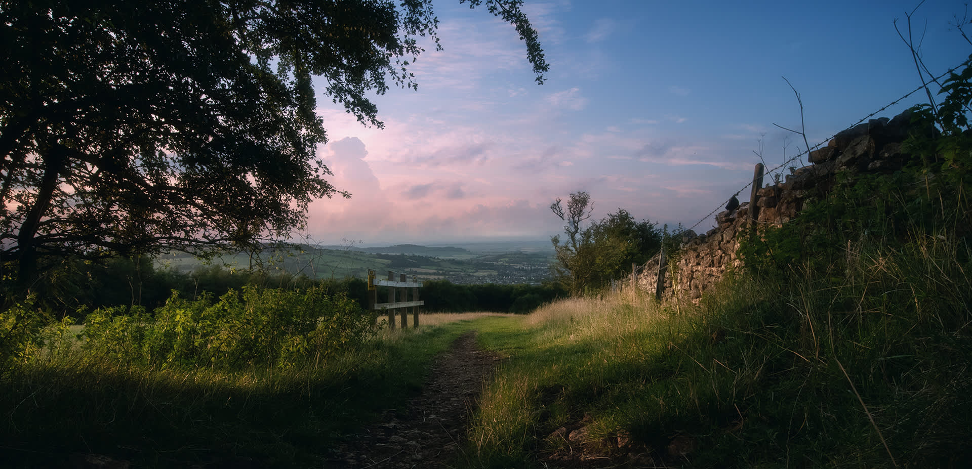 View down a gently sloping footpath with a stone wall on the right and great view ahead