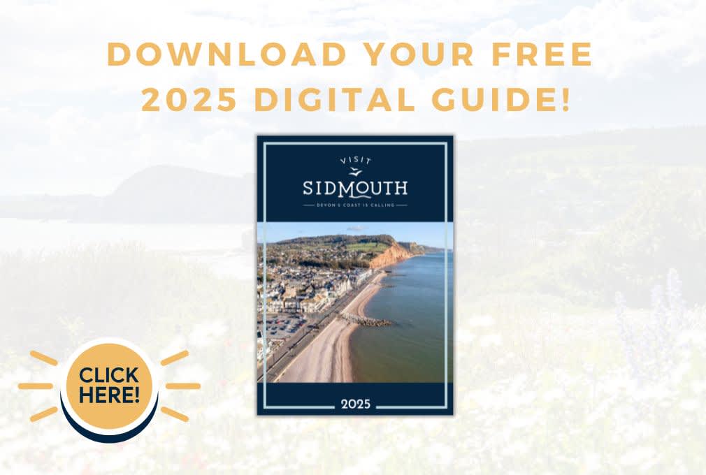 A coastal town with red cliffs and a pebble beach under a blue sky. Text reads: "Visit Sidmouth, Devon's Coast is Calling, 2025. Download your free 2025 digital guide. Click here."