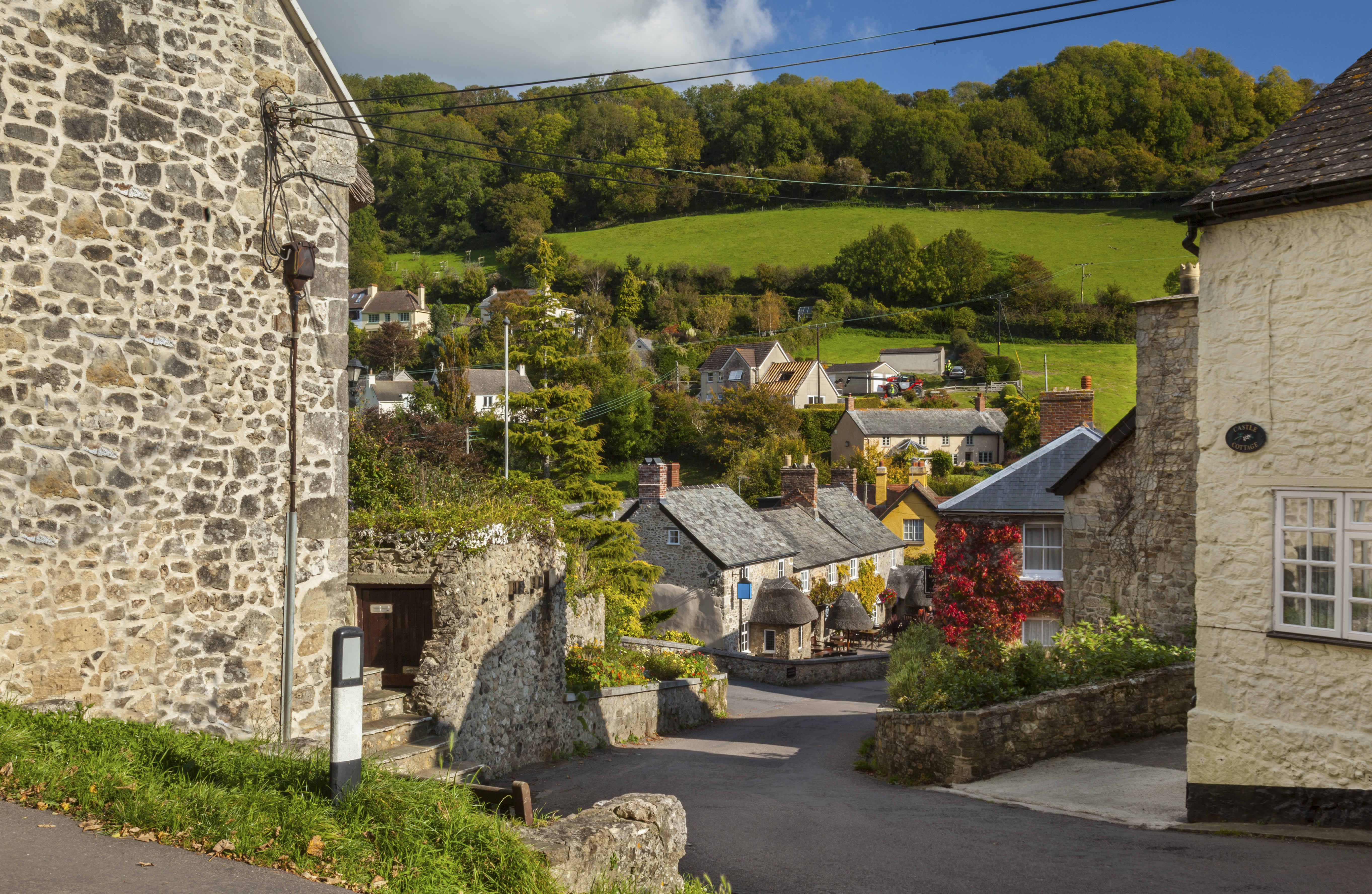 A street in Branscombe surrounded by fields and blue sky