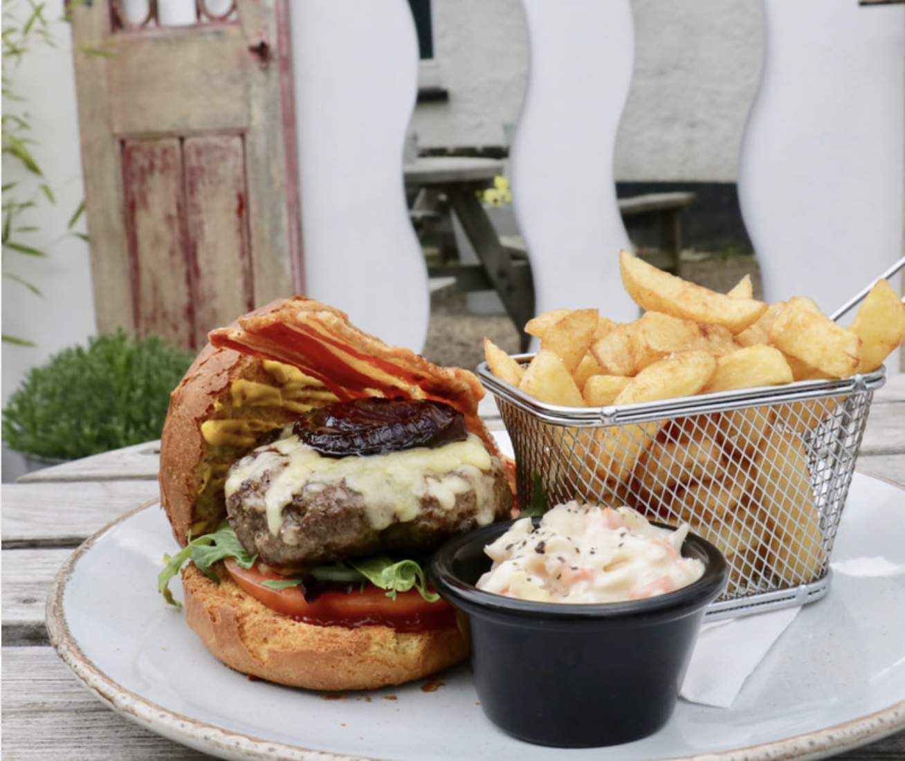 burger, chips and salad on a table in Budleigh