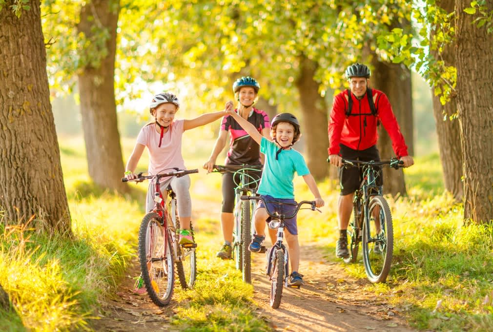 family of four two children at the front cycling on a sunny day