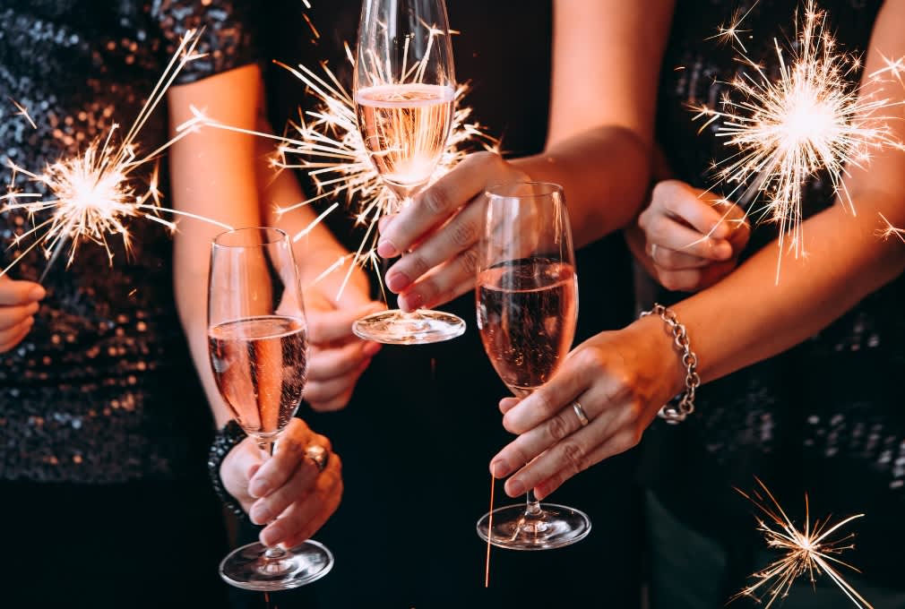people holding glasses at new years eve