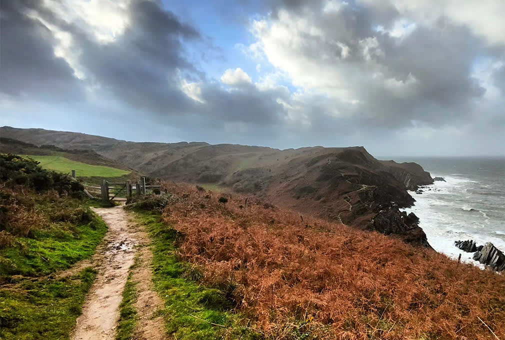 coast of Devon in Autumn, stormy clouds and view of a coastal walking path