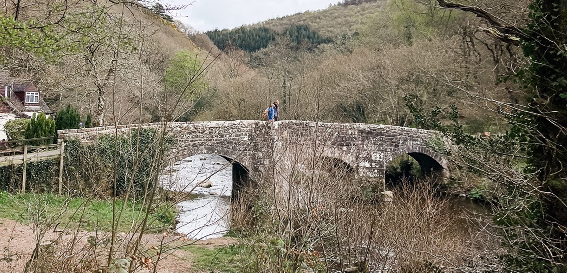 couple walking over a bridge on Dartmoor