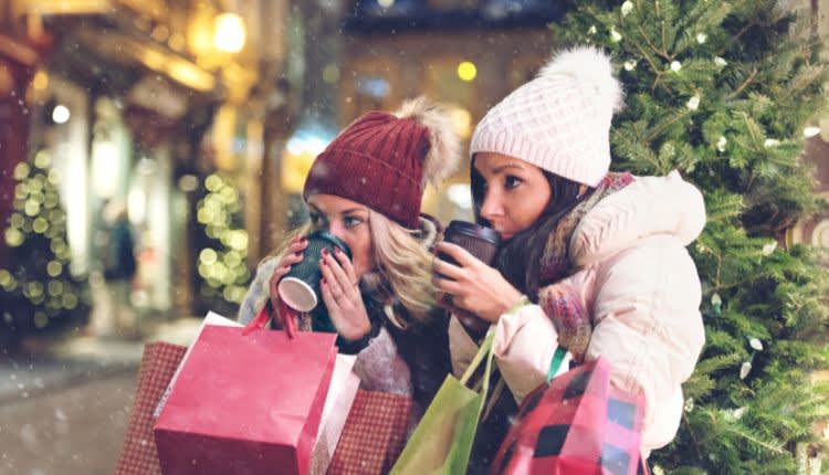 women drinking coffee while christmas shopping