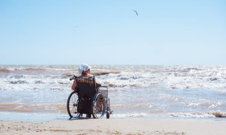 man in wheelchair on beach