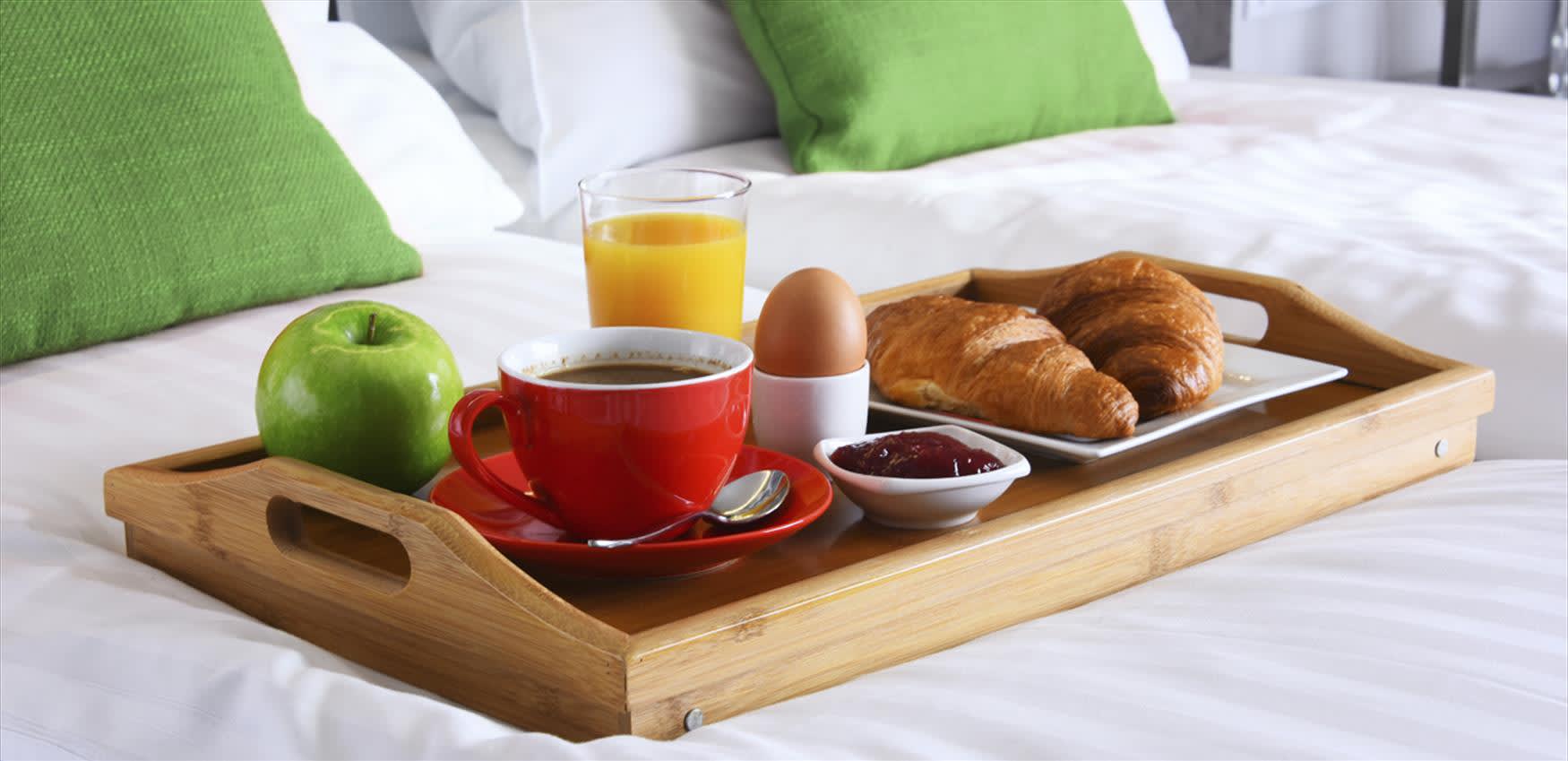 a tray with breakfast on a white bedsheet