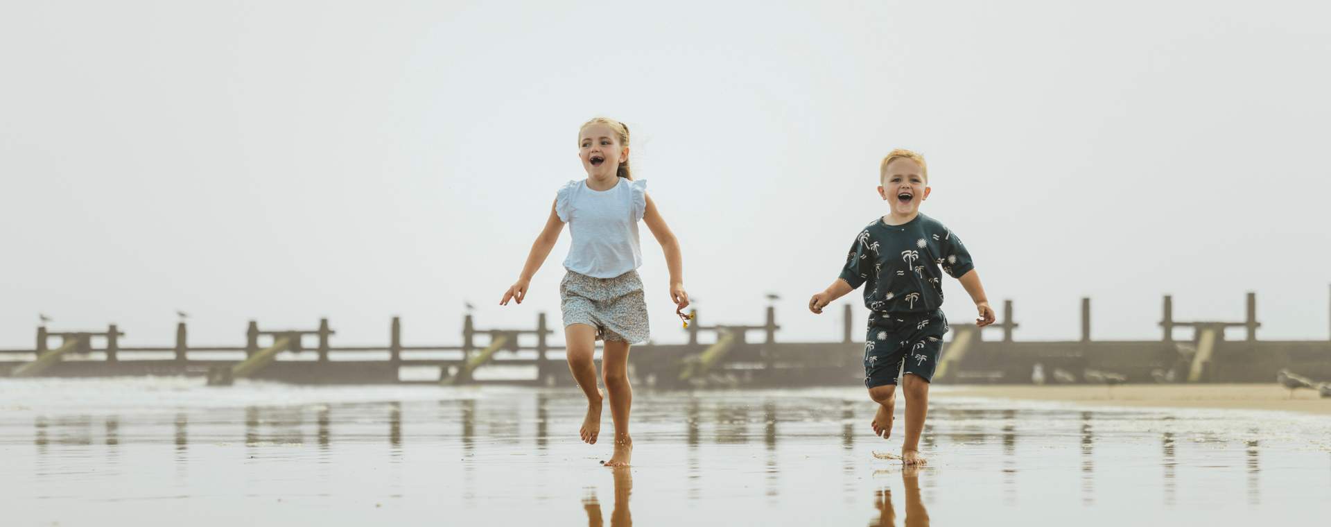 Two children running along the beach in Hornsea