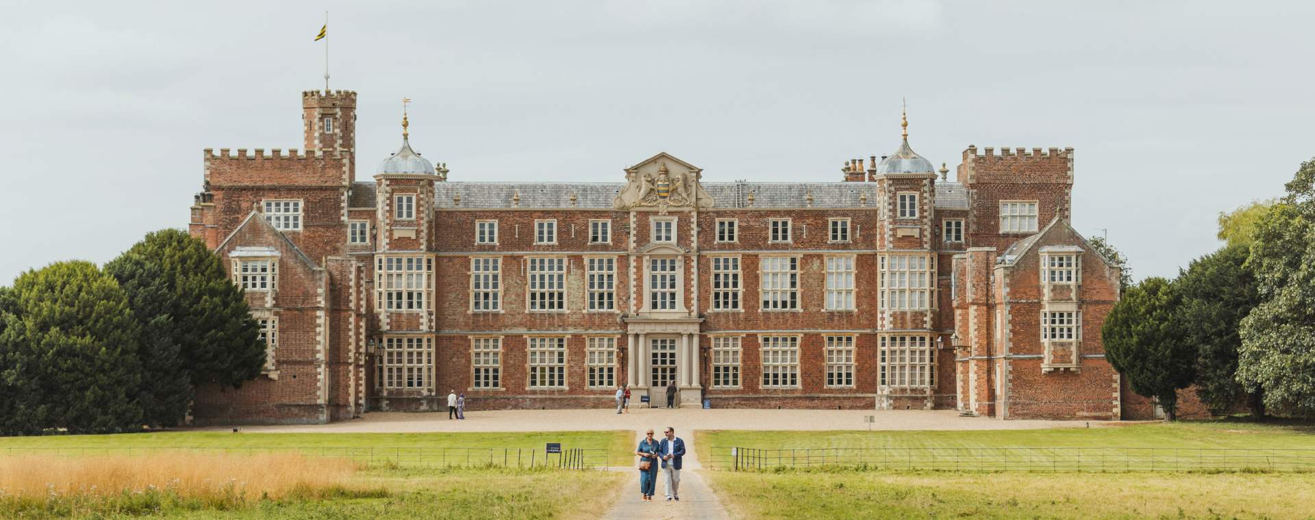 A couple walking with Burton Constable Hall in the background