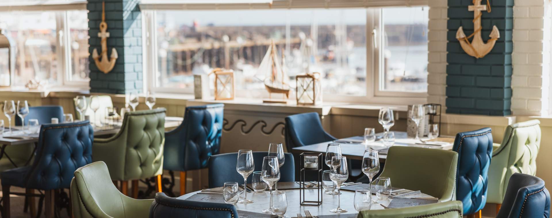 The dining area at Salt on the Harbour with Bridlington harbour visible in the background through the window.