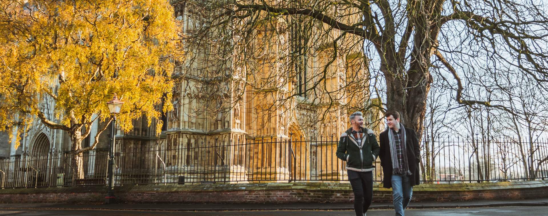 Two people walking in front of Beverley Minster