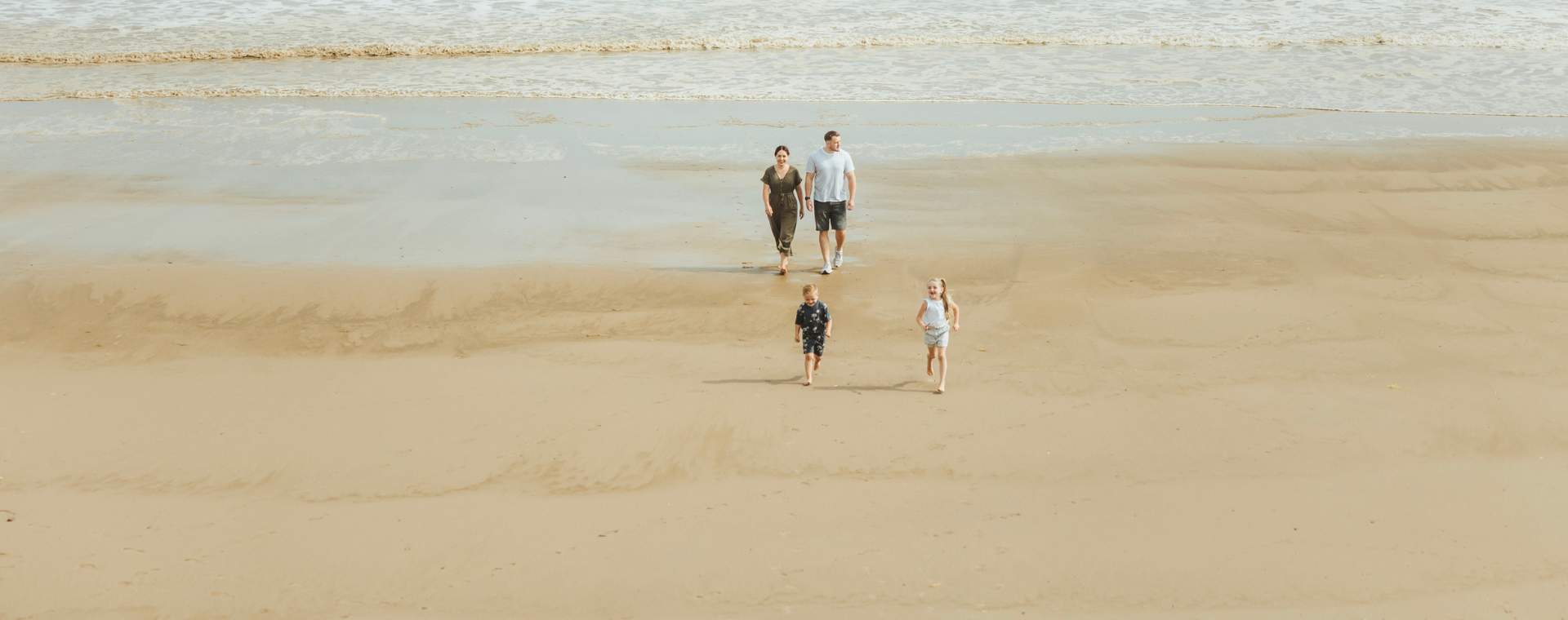A family strolling along the beach in Hornsea