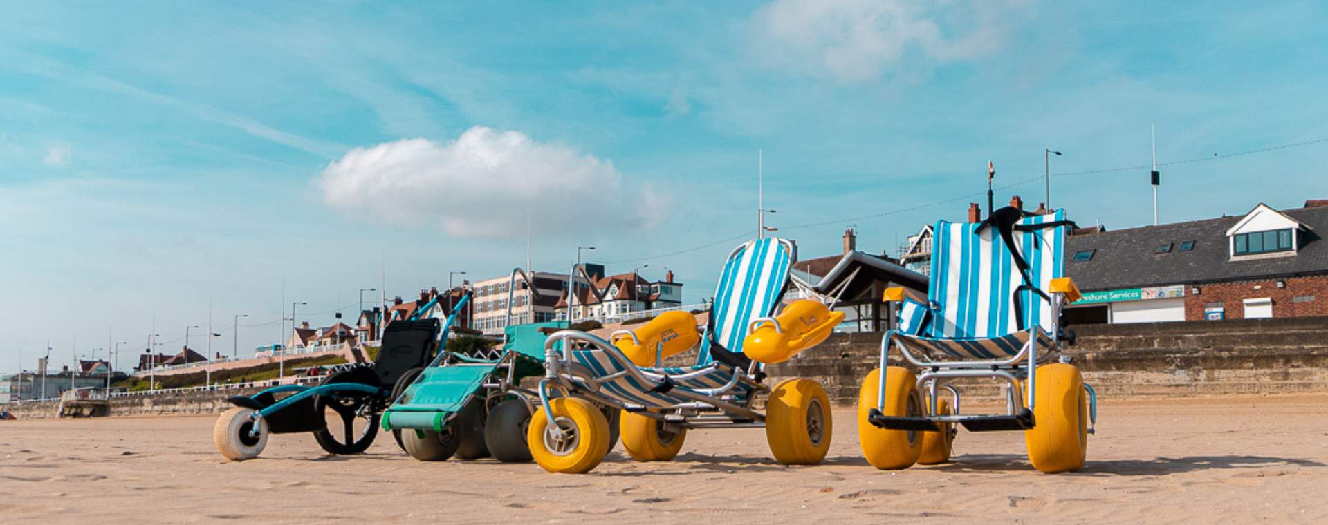 Adapted accessibility wheelchairs lined up on Bridlington Beach.