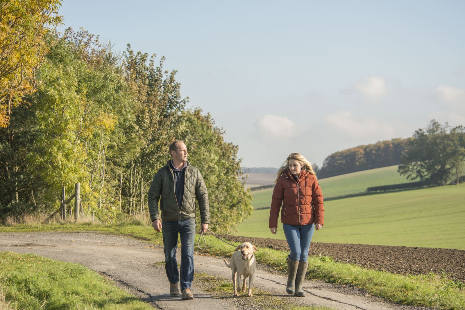 Couple walking a dog at Sledmere House in Winter
