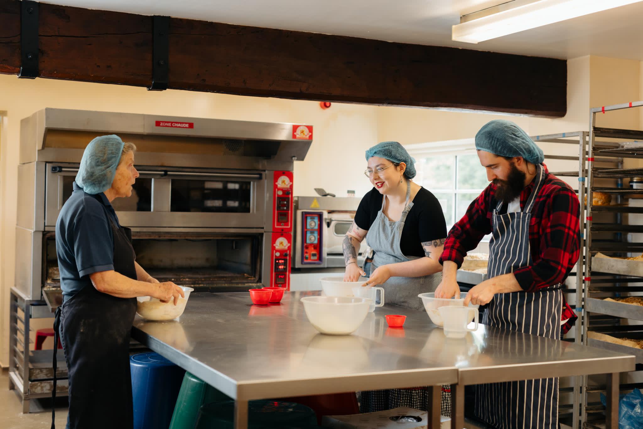 An instructor teaching visitors how to make bread at Side Oven Bakery