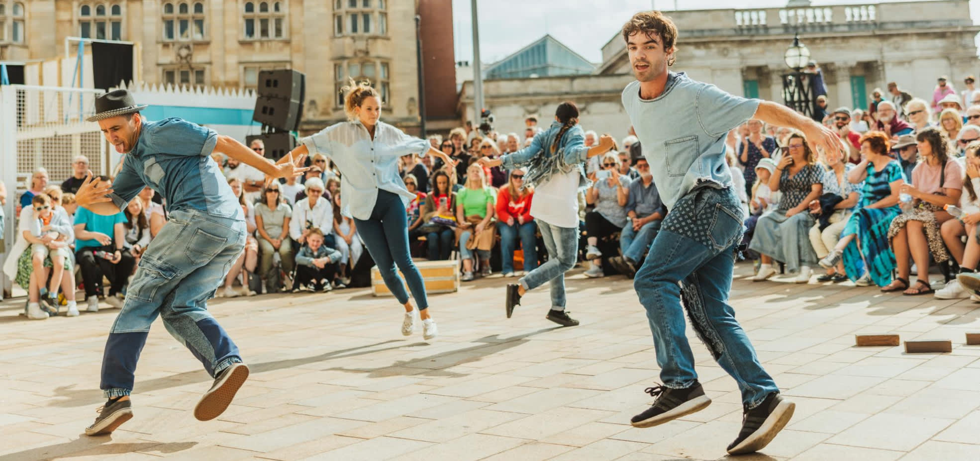 Freedom festival dancers perform in the sunshine in Queen Victoria Square with a crown surrounding them.