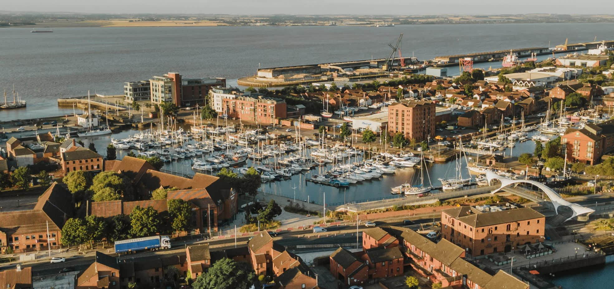 Aerial view of Hull Marina with boats, waterfront buildings, footbridge and the Humber Estuary in the background