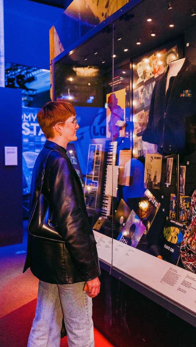 A girl looks inside a cabinet in the British Music Experience