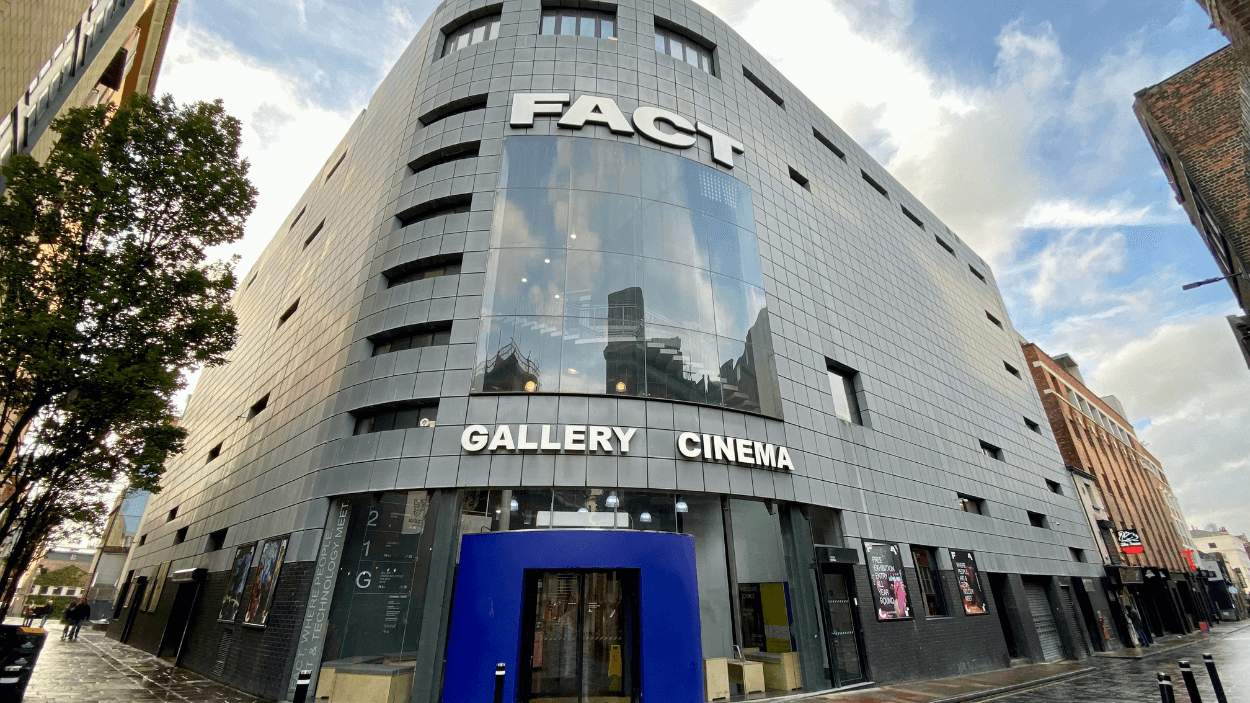 Outside of FACT art centre which is a large grey building with a purple door.