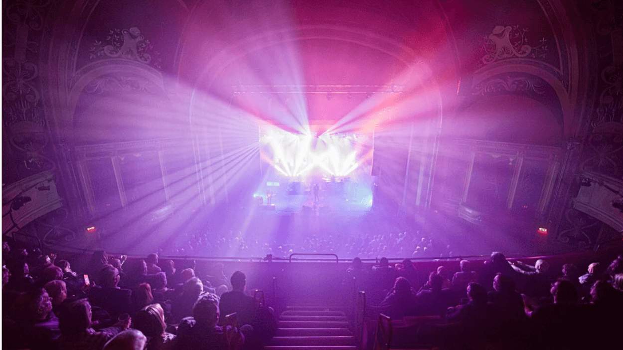A photo of Liverpool Empire from in the stands with a purple light shining up