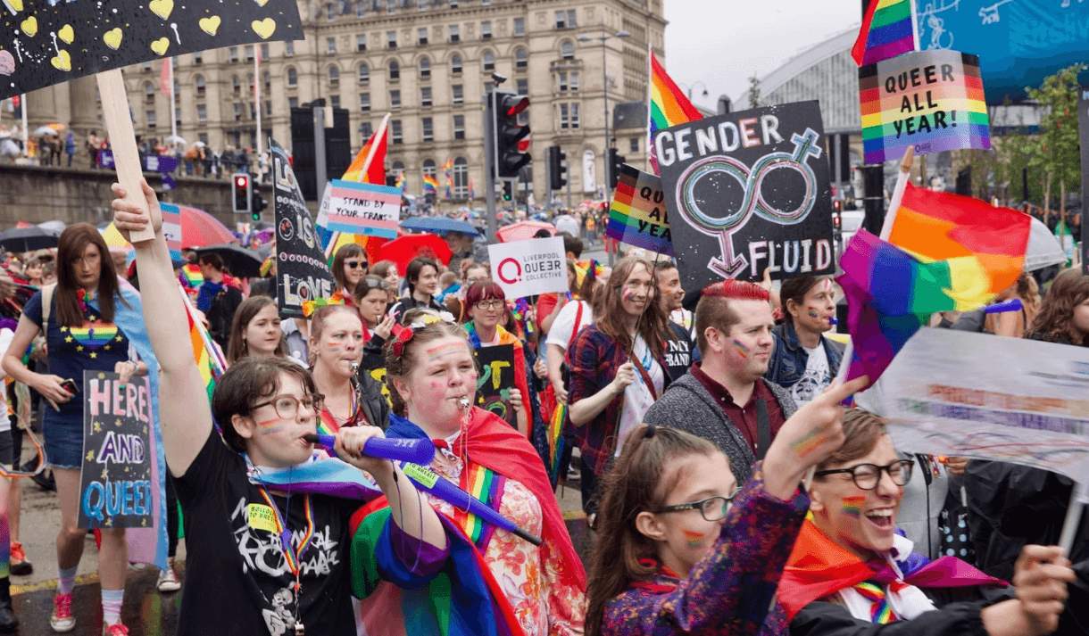 People wearing pride flags, carrying signs in the annual March with Pride in Liverpool.