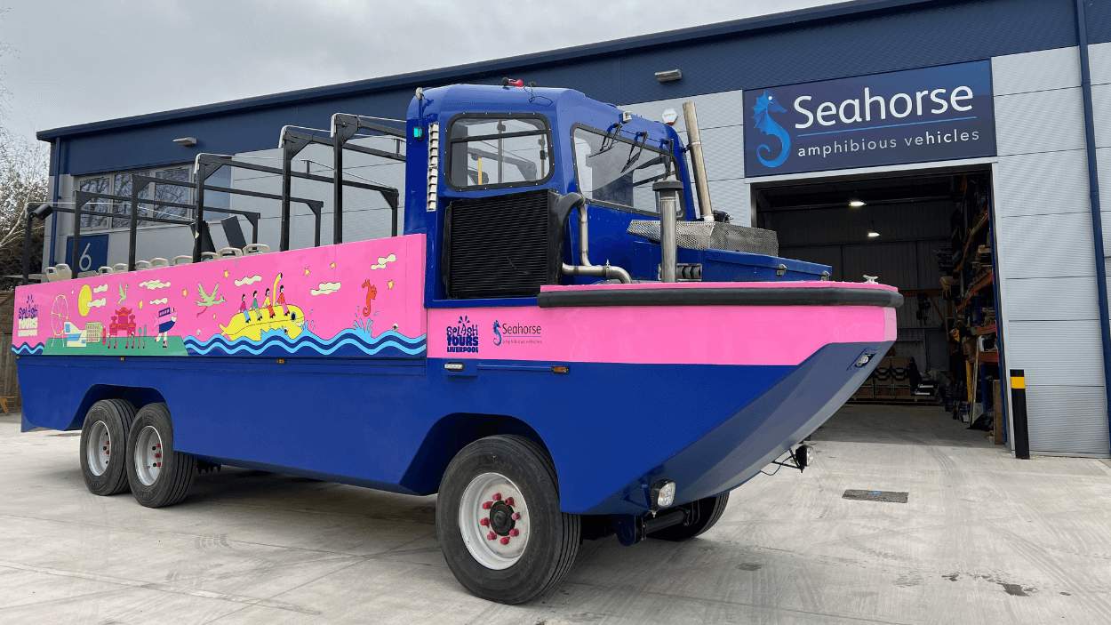 A blue and pink vehicle which drives and also goes in water.
