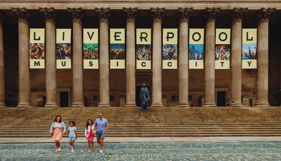 Outside of St George's Hall in Liverpool with large banners hanging between the columns that say Liverpool Music City.