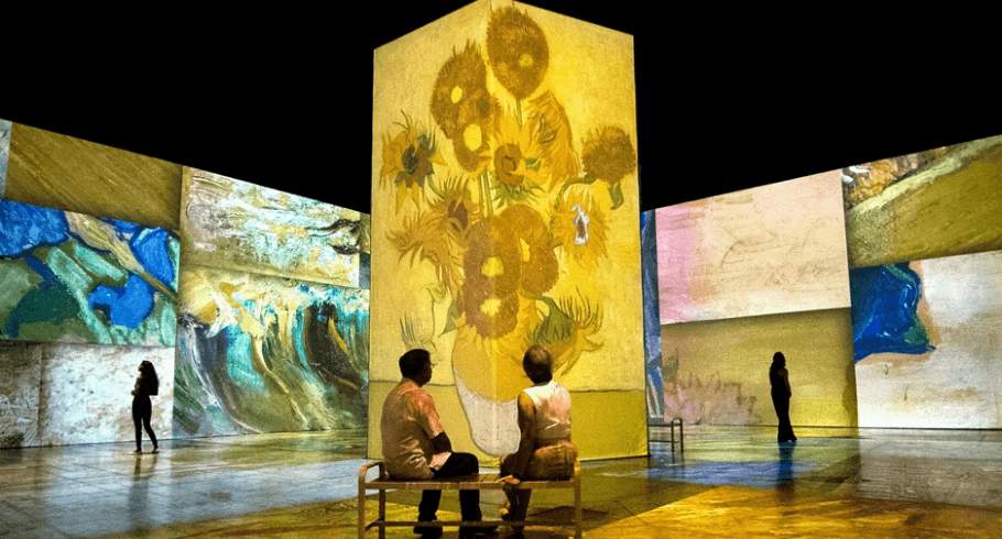 An immersive experience with projections of Van Gogh artwork on the walls.