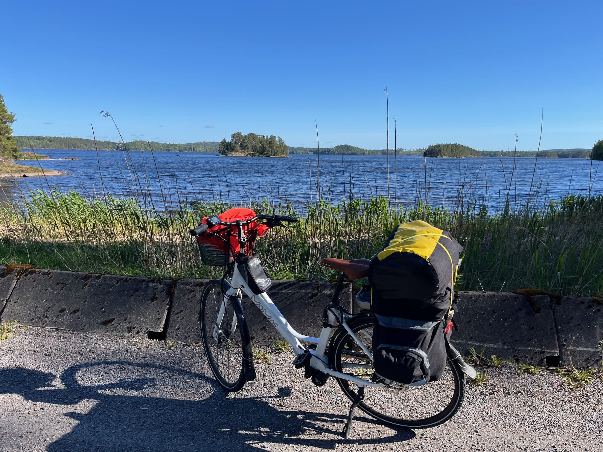 En ferdig oppakket sykkel som står foran en stor innsjø