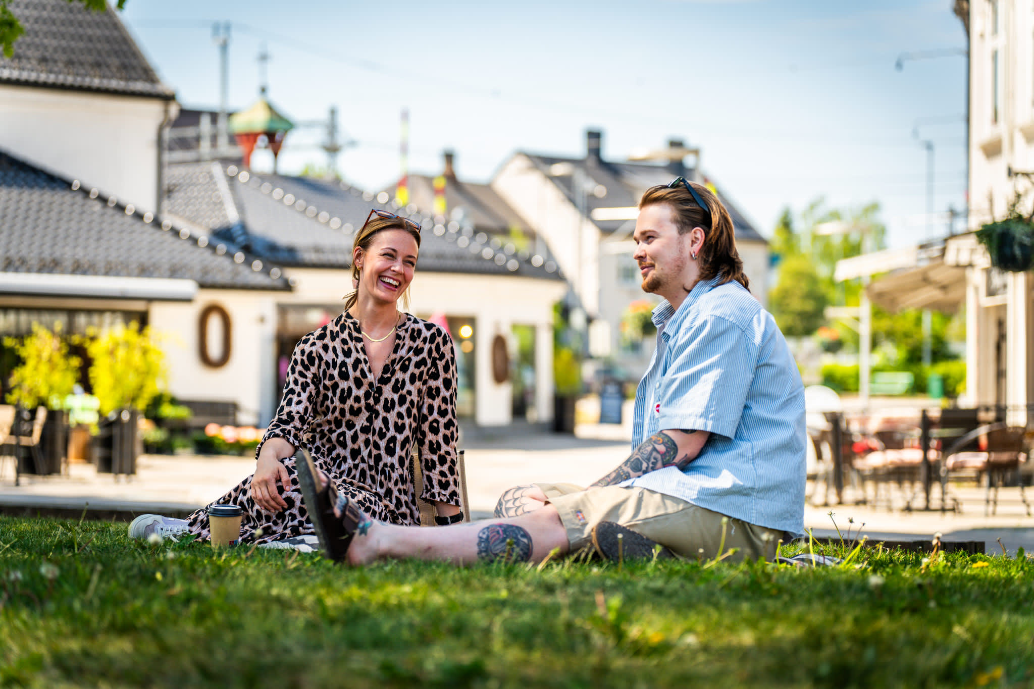 Ett par har piknikk i parken langs gågata