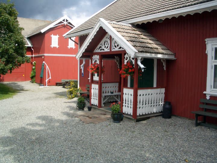 Entrances at Veslestua, with a red barn in the background