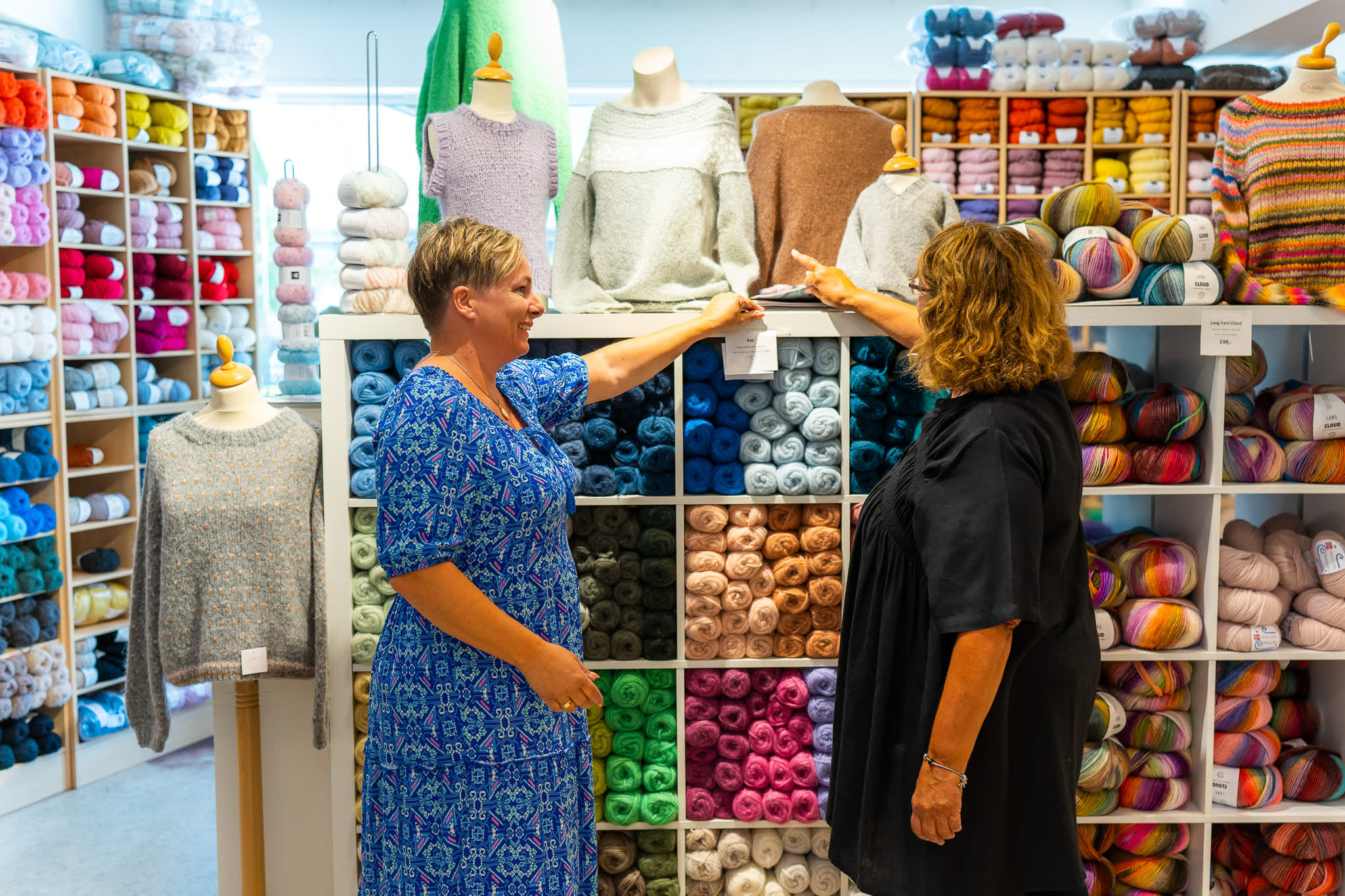 Det diskuteres strikkeoppskrifter i garnbutikken