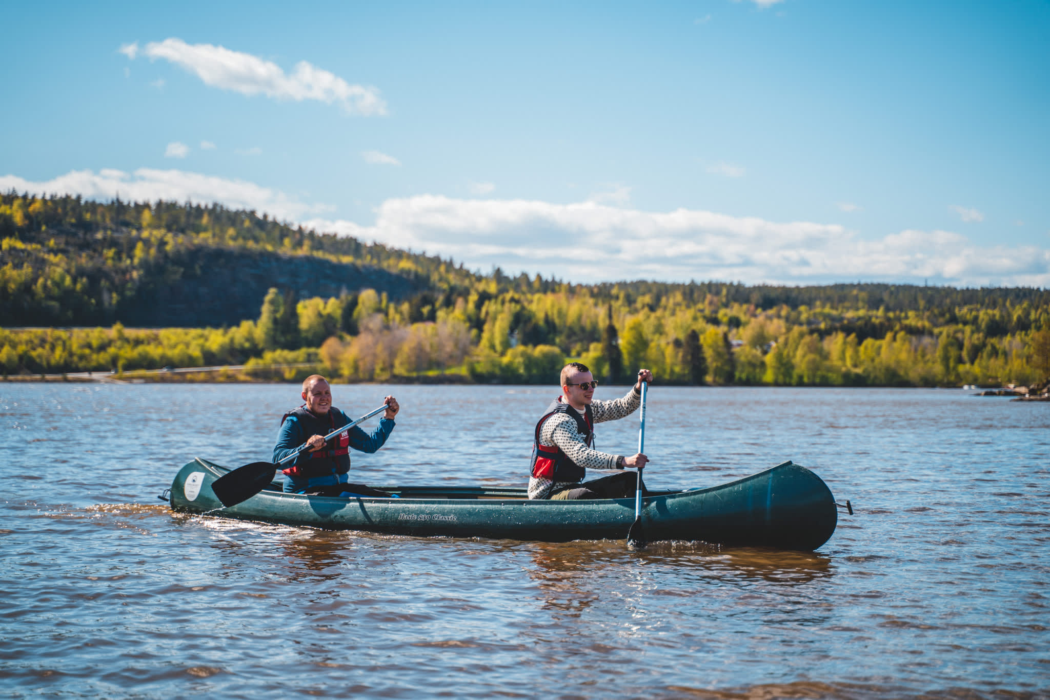 Two men are paddling a canoe in the lake.