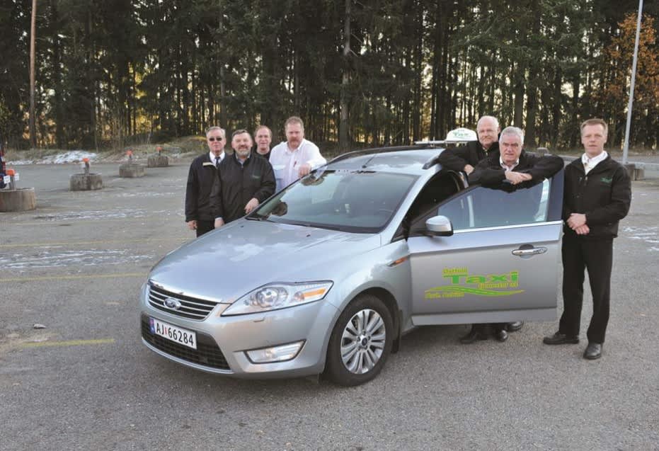 En bil med taxireklame på en gresslette