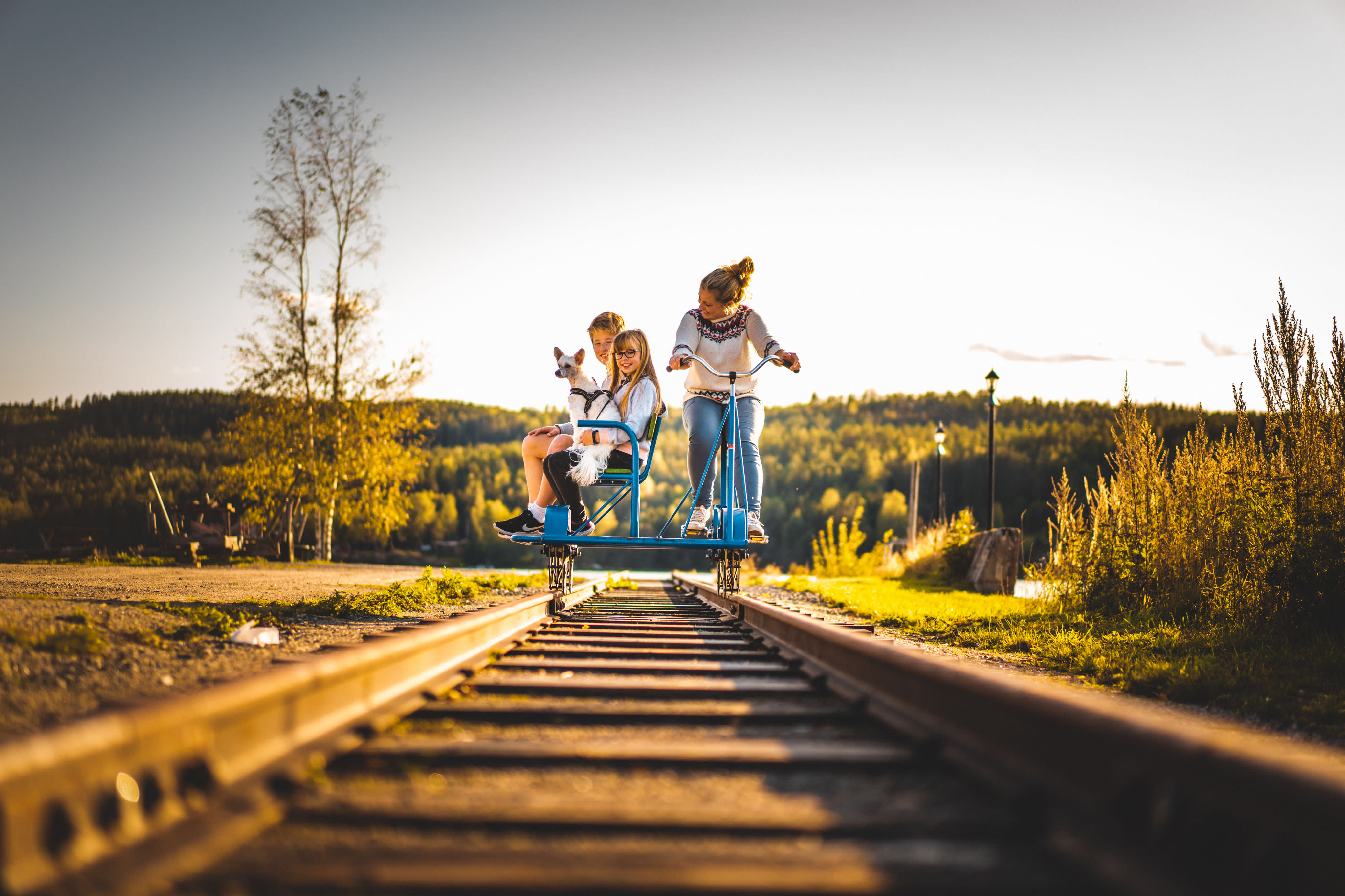 Kvinne og to barn sykler dresin på togskinnene ved Skulerud Brygge.